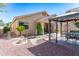 Landscaped backyard featuring a gazebo, bridge over decorative stones, mature plants, and a view of the home's exterior at 14436 W Ventura St, Surprise, AZ 85379