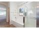 Bright bathroom features a shower, soaking tub, tile floors, and transom window at 14436 W Ventura St, Surprise, AZ 85379