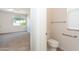 Bright bedroom with neutral carpet features a toilet room and view to the front yard at 14436 W Ventura St, Surprise, AZ 85379
