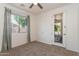 Carpeted bedroom with a window, ceiling fan, and a door leading to outdoor living area at 14436 W Ventura St, Surprise, AZ 85379