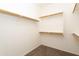 Walk-in closet featuring neutral carpet, wooden closet rods, and white shelving at 14436 W Ventura St, Surprise, AZ 85379