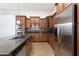 This kitchen features wooden cabinets, stainless steel appliances, granite counter tops, and tile flooring at 14436 W Ventura St, Surprise, AZ 85379
