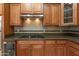 Close-up view of the kitchen with granite countertops, tile backsplash, and wooden cabinetry at 14436 W Ventura St, Surprise, AZ 85379