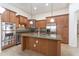 Spacious kitchen features wooden cabinetry, granite countertops, stainless steel appliances, and a center island at 14436 W Ventura St, Surprise, AZ 85379