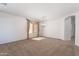 Spacious carpeted living room with natural light, elegant chandelier, and neutral decor at 14436 W Ventura St, Surprise, AZ 85379