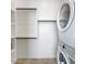 Well-lit laundry room boasts a washer and dryer and built-in storage shelves at 15044 W Gray Fox Trl, Surprise, AZ 85387