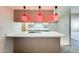 Open kitchen featuring a large counter with cooktop and retro pink pendant lights at 15608 N 57Th Dr, Glendale, AZ 85306