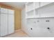 Bright laundry room with ample storage cabinets and utility connections at 15608 N 57Th Dr, Glendale, AZ 85306