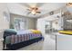Bright bedroom with ceiling fan and carpeted floor features an ensuite sitting area at 15969 W Adams St, Goodyear, AZ 85338