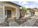 Close-up of the home's entryway with a stone archway and potted flowers at 15969 W Adams St, Goodyear, AZ 85338