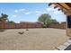 Low-maintenance backyard with rock landscaping, mature trees, and a sturdy brick wall for privacy and serenity at 16469 W Century Plant Dr, Surprise, AZ 85387
