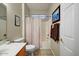 Well-lit bathroom features a shower with curtain, tiled floor, and vanity for a functional and clean space at 16469 W Century Plant Dr, Surprise, AZ 85387