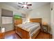 Relaxing bedroom with a wood-frame bed, ceiling fan, and a view of the television atop a dresser at 16469 W Century Plant Dr, Surprise, AZ 85387
