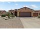 Charming single-story home with a two-car garage, desert landscaping, and a warm, inviting facade at 16469 W Century Plant Dr, Surprise, AZ 85387