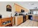 Functional kitchen with black appliances, wood cabinets, and a vintage-style wine rack at 16469 W Century Plant Dr, Surprise, AZ 85387