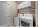 Functional laundry room with modern washer and dryer, ample storage, and easy access to laundry essentials at 16469 W Century Plant Dr, Surprise, AZ 85387