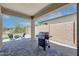 A covered back patio that includes a grill, chairs and a fire pit, creating an inviting outdoor space at 16528 W Pedro Ln, Goodyear, AZ 85338