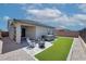 Inviting backyard featuring a hot tub, a fire pit, and an artificial grass area, perfect for relaxation and entertainment at 16528 W Pedro Ln, Goodyear, AZ 85338