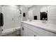 Modern bathroom featuring dual sinks, a walk-in shower with a rainfall shower head, and white cabinets at 16528 W Pedro Ln, Goodyear, AZ 85338