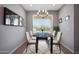 Elegant dining room boasts a modern chandelier, glass-top table, and large window at 16528 W Pedro Ln, Goodyear, AZ 85338