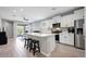 Open-concept kitchen with white cabinets, stainless steel appliances, and a spacious island seating area at 16528 W Pedro Ln, Goodyear, AZ 85338