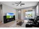 Well-lit living room leads to an outdoor patio featuring a sleek ceiling fan at 16528 W Pedro Ln, Goodyear, AZ 85338