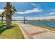 Scenic walking path by a lake, complemented by palm trees and lush landscaping for a serene outdoor experience at 16528 W Pedro Ln, Goodyear, AZ 85338