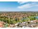 Wide aerial view of the neighborhood with homes, golf course, ponds, and scenic mountain views at 18854 N 73Rd Dr, Glendale, AZ 85308
