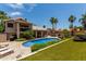 Expansive backyard featuring a pool, patio, artificial turf, and lush landscaping at 18854 N 73Rd Dr, Glendale, AZ 85308