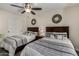 Charming bedroom with two beds, stylish decor, and a ceiling fan at 18854 N 73Rd Dr, Glendale, AZ 85308