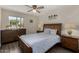 Comfortable bedroom with a window, ceiling fan, and sleek hardwood floors at 18854 N 73Rd Dr, Glendale, AZ 85308