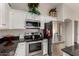 Kitchen with stainless steel appliances, black countertops, and white cabinetry providing ample storage at 18854 N 73Rd Dr, Glendale, AZ 85308