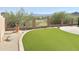 Beautiful backyard featuring artificial grass, desert landscaping, and views of the golf course and mountains at 2053 E Clubhouse Dr, Phoenix, AZ 85048