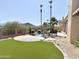 Beautiful backyard featuring artificial grass, a private pool, mature palms, and mountain views at 2053 E Clubhouse Dr, Phoenix, AZ 85048