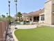 Stunning backyard features a private pool, waterfall feature, mature palms, and artificial grass at 2053 E Clubhouse Dr, Phoenix, AZ 85048