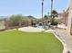 Spacious backyard featuring artificial turf, desert landscaping, wrought-iron fencing, and a pool with mountain views at 2053 E Clubhouse Dr, Phoenix, AZ 85048