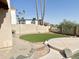 Well-designed backyard with artificial turf, stone accents, and a view of the pool and nearby stucco wall at 2053 E Clubhouse Dr, Phoenix, AZ 85048