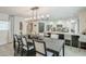 Elegant dining room with decorative lighting, a long table with chairs and a view to an adjacent kitchen at 2109 W Berridge Ln, Phoenix, AZ 85015