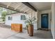 Charming home featuring a blue front door, neutral tones, and decorative potted plants on the covered front porch at 2109 W Berridge Ln, Phoenix, AZ 85015
