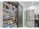 Pantry featuring ample shelving, sliding door, stocked with food, and adjacent to stainless steel refrigerator at 2109 W Berridge Ln, Phoenix, AZ 85015