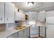 Galley kitchen featuring white cabinetry, gas range, and tile backsplash at 2129 N Summer St, Mesa, AZ 85203
