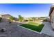 The backyard features a manicured lawn, gravel landscaping, and custom patio, offering a private outdoor oasis at 2236 W Aston Dr, San Tan Valley, AZ 85144