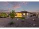 Expansive backyard boasts desert landscaping, a manicured lawn, and seamless transition to the covered patio at 2236 W Aston Dr, San Tan Valley, AZ 85144