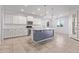 Open kitchen featuring stainless appliances, white cabinets, an island and modern lighting at 2236 W Aston Dr, San Tan Valley, AZ 85144
