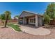 Backyard with covered patio, artificial grass, desert landscaping, and palm tree at 2542 E Los Alamos St, Gilbert, AZ 85295