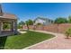 Backyard with artificial grass, desert landscaping, and covered patio with brick pavers at 2542 E Los Alamos St, Gilbert, AZ 85295