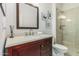 Bathroom features a wood vanity, framed mirror, and glass shower with tile surround at 2542 E Los Alamos St, Gilbert, AZ 85295