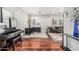 Bright living room with hardwood floors, a dark wood desk, and a brown leather couch at 2542 E Los Alamos St, Gilbert, AZ 85295