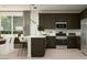 Modern kitchen featuring dark cabinets, stainless steel appliances, and bar seating, perfect for entertaining at 3122 S 156Th Ave, Goodyear, AZ 85338