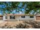 Charming single-story home featuring a brick facade, complemented by mature trees and a well-maintained lawn at 3238 W Rose Ln, Phoenix, AZ 85017